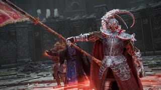 Elden Ring screenshot showing three players stood in a row in a colosseum, one of them pointing a flag pole towards other players.